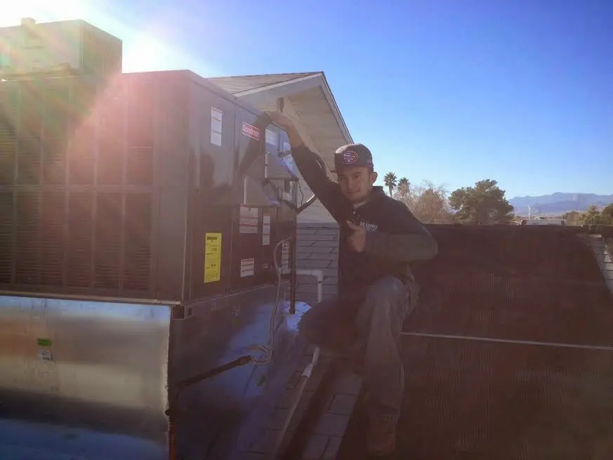 HVAC technician performing HVAC Inspection on a rooftop unit in Brockport